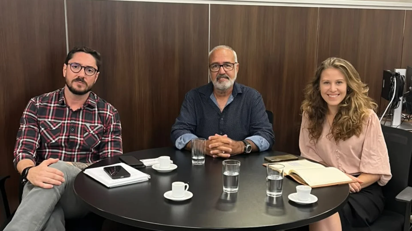 Ricardo Romanetto, presidente da Nova Abrase, entre Max Abreu e Carolina Moulin, da Semad, sentados à mesa de reunião